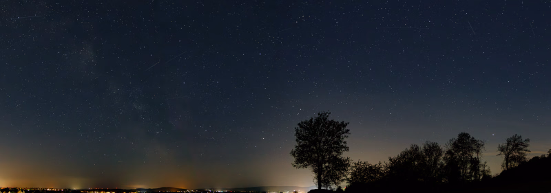 Nachthimmel Am Hapkenberge, März 2026, südl. Himmel mit Stern Antares, Sternbild Skorpion, Bäume im Vordergrund, Lichter von Gehrden am Horizont